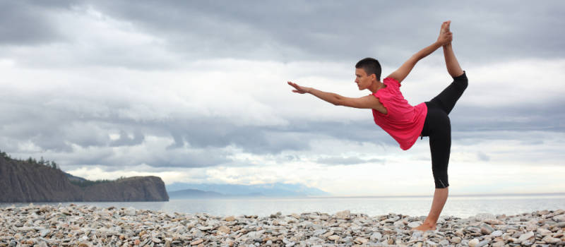 woman doing yoga on beach